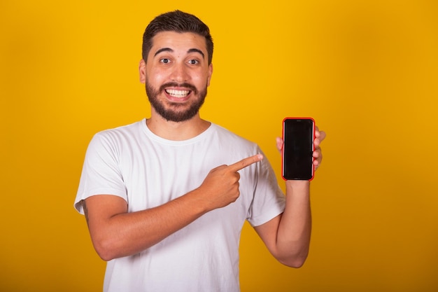 Hombre latinoamericano brasileño con la mano apuntando a la pantalla del teléfono celular para la comunicación de la aplicación