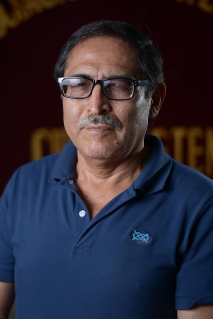 Foto hombre latinoamericano de mediana edad con piel oscura con gafas y un polo azul en primer plano