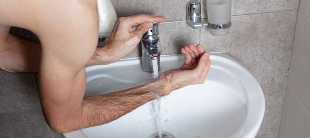 El hombre se lava en el baño.