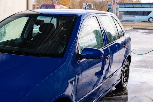 Un hombre lavando un auto en un lavadero de autos