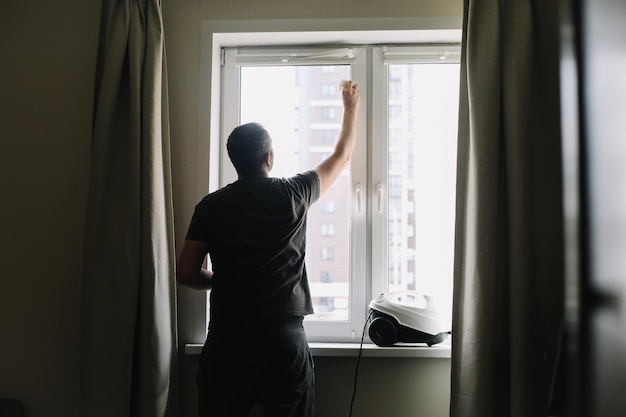 Hombre lavando y limpiando ventanas en casa Tareas domésticas y limpieza higiene del hogar