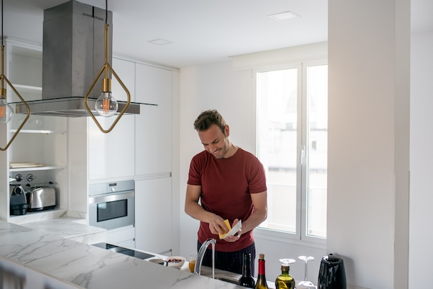 Hombre lavando platos en una cocina moderna