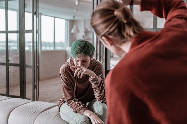 Foto hombre levantando la mano. hombre enojado agresivo de pelo rubio levantando la mano sobre su joven esposa indefensa