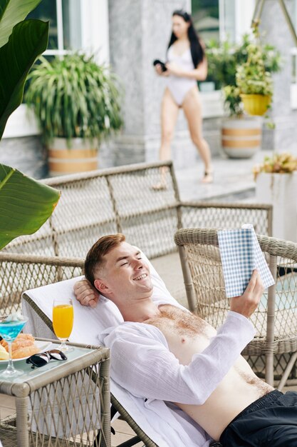 Hombre leyendo y desayunando al aire libre