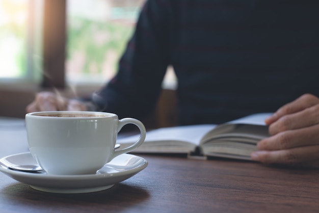 Hombre leyendo libro en cafetería