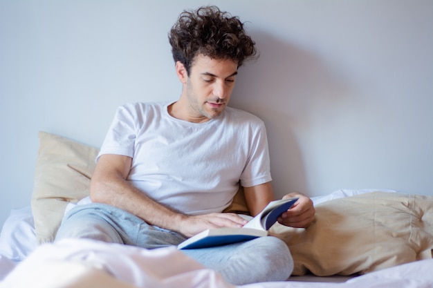 Hombre leyendo un libro en la cama