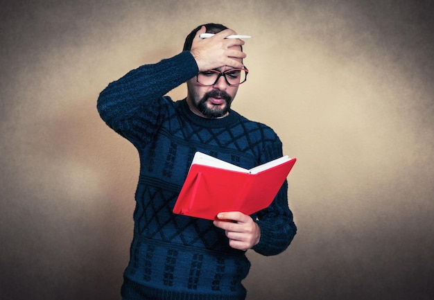 Foto hombre leyendo un libro contra la pared