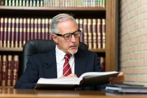 Hombre leyendo un libro en su biblioteca