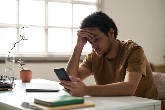 Hombre leyendo mensaje con malas noticias