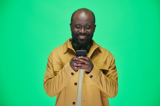 Hombre leyendo mensaje en teléfono móvil y sonriendo