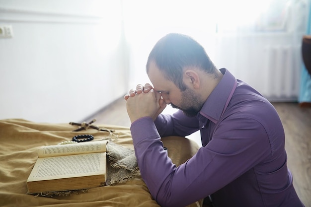 Hombre leyendo y orando de la santa biblia cerca de la cama por la noche Cristianos y concepto de estudio bíblico Estudiar la Palabra de Dios en la iglesia