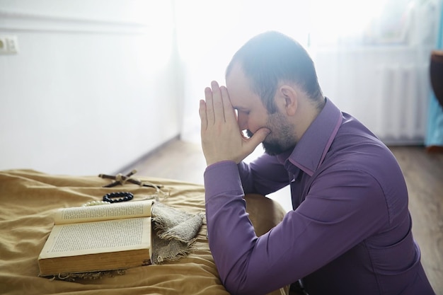 Hombre leyendo y orando de la santa biblia cerca de la cama por la noche Cristianos y concepto de estudio bíblico Estudiar la Palabra de Dios en la iglesia