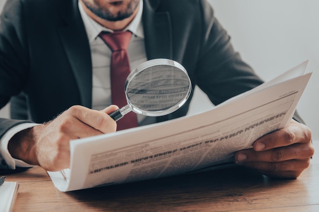 Foto hombre leyendo el periódico con lupa