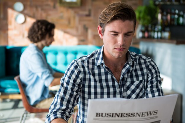 Hombre leyendo un periódico de negocios