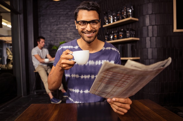 Hombre leyendo el periódico y tomando café