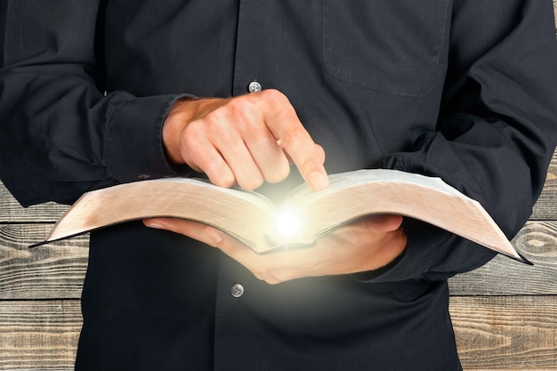 Foto hombre leyendo viejo libro pesado sobre fondo