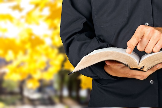 Hombre leyendo viejo libro pesado sobre fondo