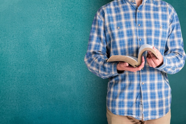 Hombre leyendo viejo libro pesado sobre fondo