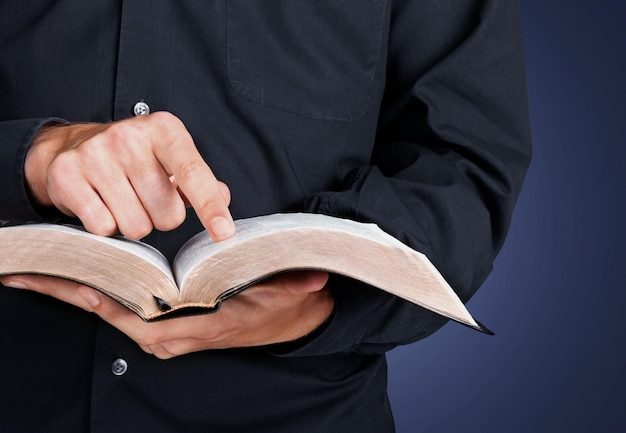 Hombre leyendo viejo libro pesado sobre fondo