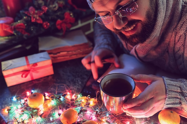 Un hombre con un libro en blanco en sus manos para la mesa de año nuevo con adornos