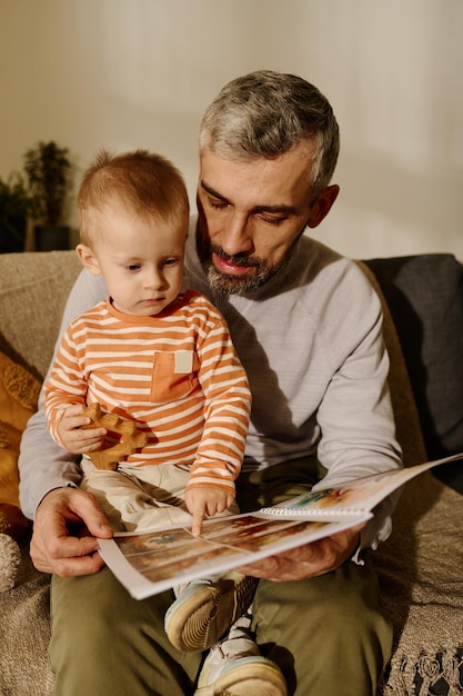 Hombre con libro de cómics y su hijo bebé