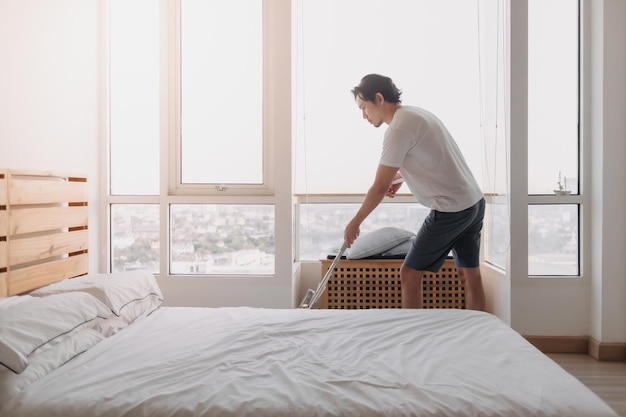 Hombre limpia su apartamento dormitorio con fregona
