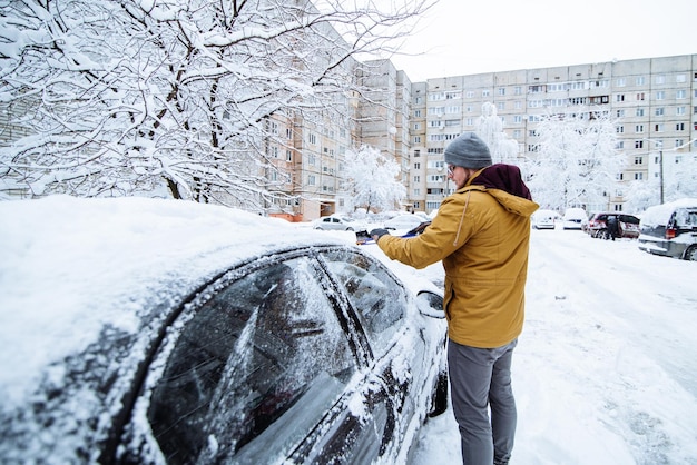 Hombre limpiando auto después de tormenta de nieve