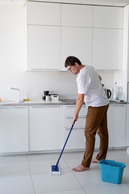 Hombre limpiando casa con fregona