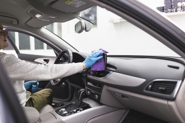 Un hombre limpiando el interior del automóvil, el concepto de detalles (o valeting) del automóvil. Enfoque selectivo.