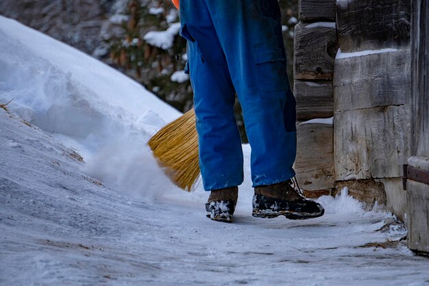 Hombre limpiando nieve con una escoba