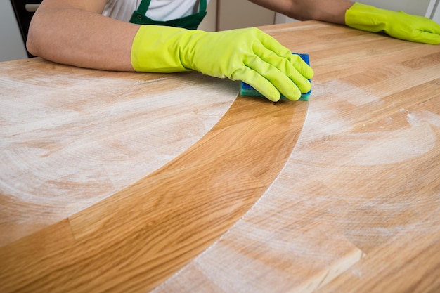 Hombre limpiando polvo sobre mesa de madera