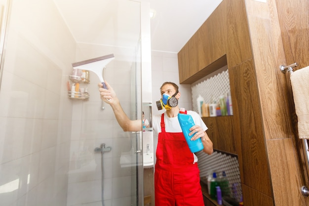 Foto un hombre limpiando un vaso de ducha.