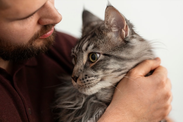 Foto hombre con un lindo gato en casa