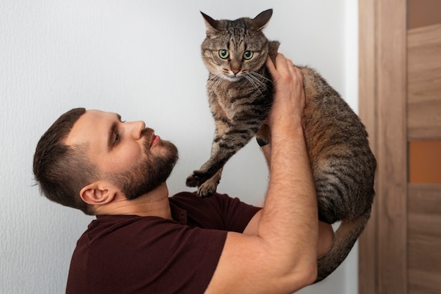 Foto hombre con un lindo gato en casa