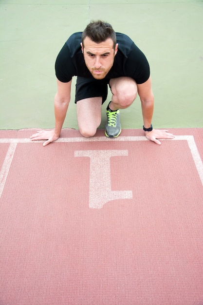 Foto hombre listo para correr en la pista