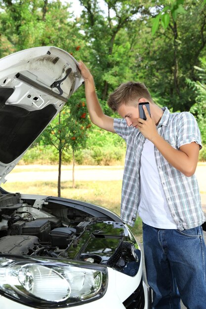 Foto hombre llamando al servicio de reparación después de la avería del coche