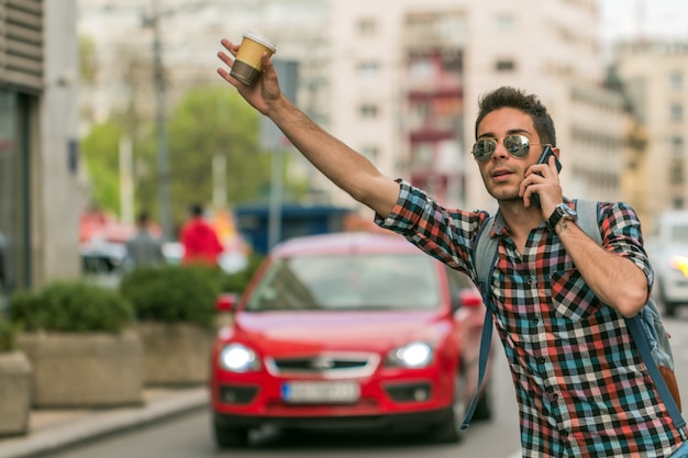 Hombre llamando taxi en la calle de la ciudad