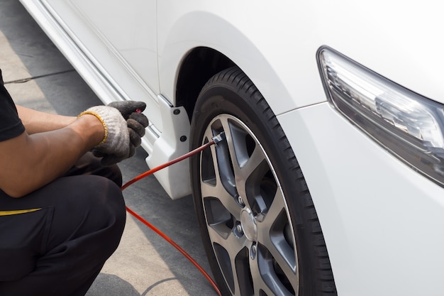 Hombre llenando aire en los neumáticos del coche