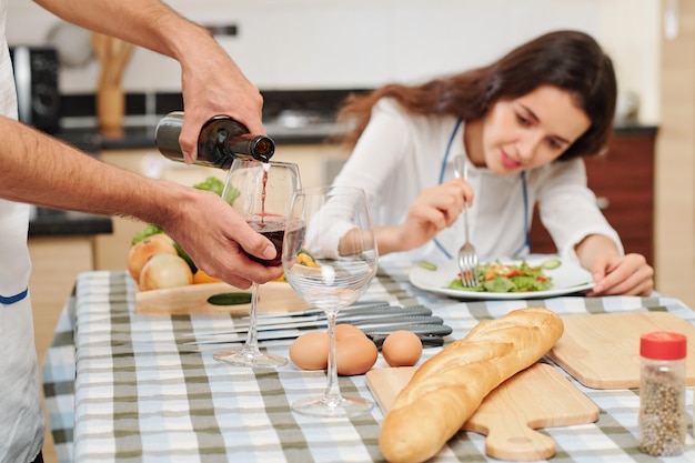 Hombre llenando copas de vino