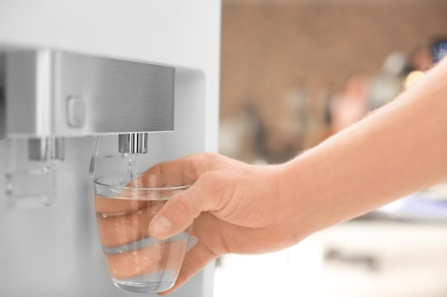 Foto hombre llenando vaso de enfriador de agua closeup