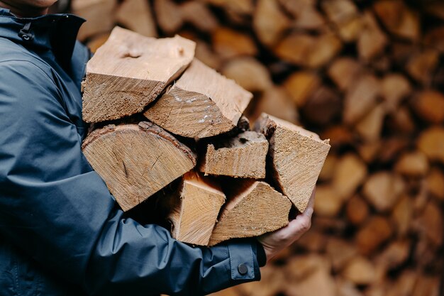 El hombre lleva montón de madera