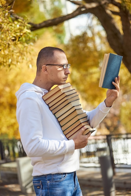 El hombre lleva muchos libros en sus manos