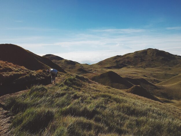 Foto hombre llevando un saco mientras camina por el campo contra el cielo