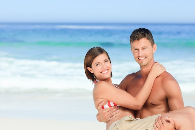 Hombre llevando a su esposa en la playa