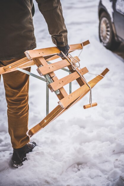 Hombre llevando trineo en la nieve