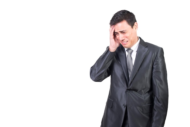 Hombre llorando en traje formal tocando la cabeza