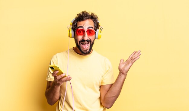 Hombre loco expresivo que se siente feliz y asombrado por algo increíble con auriculares