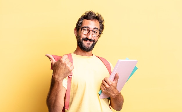 Hombre loco expresivo que se siente orgulloso, sonriendo positivamente con los pulgares hacia arriba. concepto de estudiante adulto