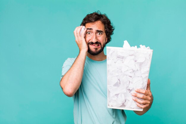 El hombre loco hispano adulto joven falla y el concepto de basura de bolas de papel