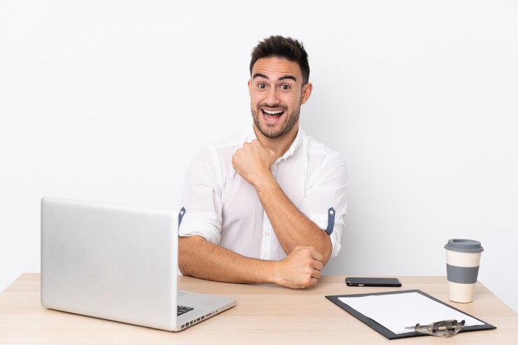 Foto hombre en un lugar de trabajo con una computadora portátil